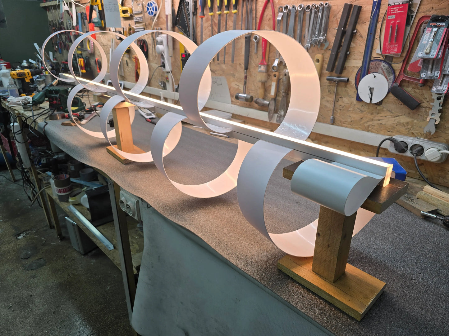 Handcrafted metal lamp prototype with illuminated circular modules, photographed during the making process in the CristofaroLuce atelier.