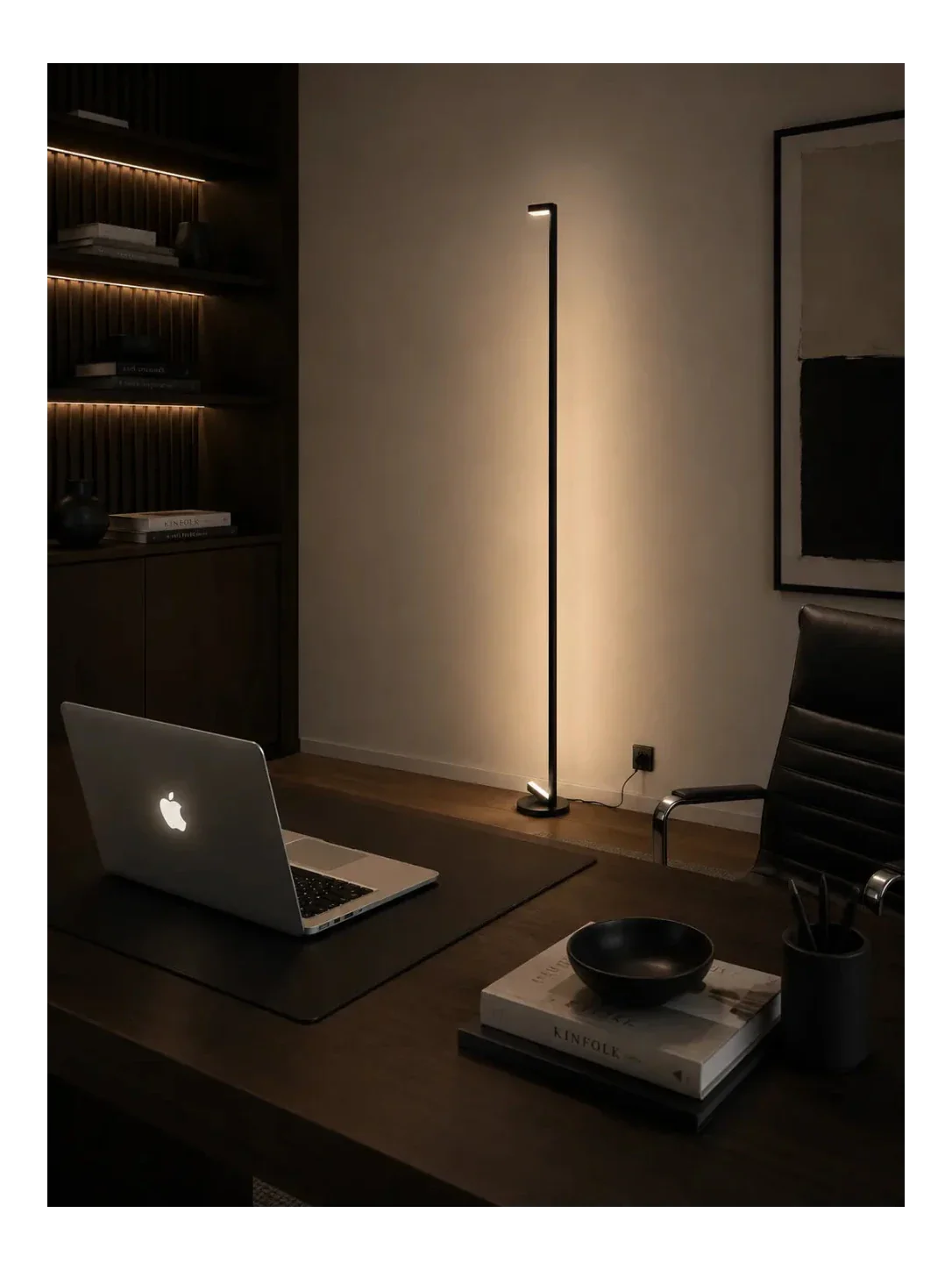 Warm indirect sculptural floor lamp creating a soft atmospheric glow against a wall in a calm minimalist interior