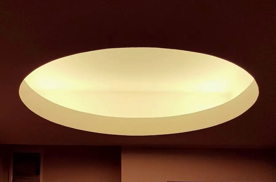 Artisanal lamp casting soft indirect light on a wall, creating a calm and balanced interior atmosphere