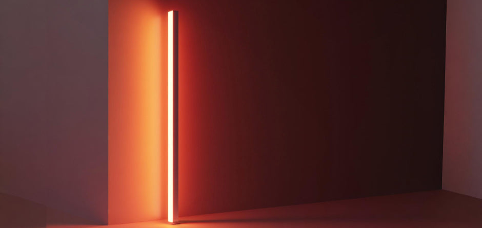 minimalist floor lamp creating soft shadows on wall with indirect warm light and strong spatial depth