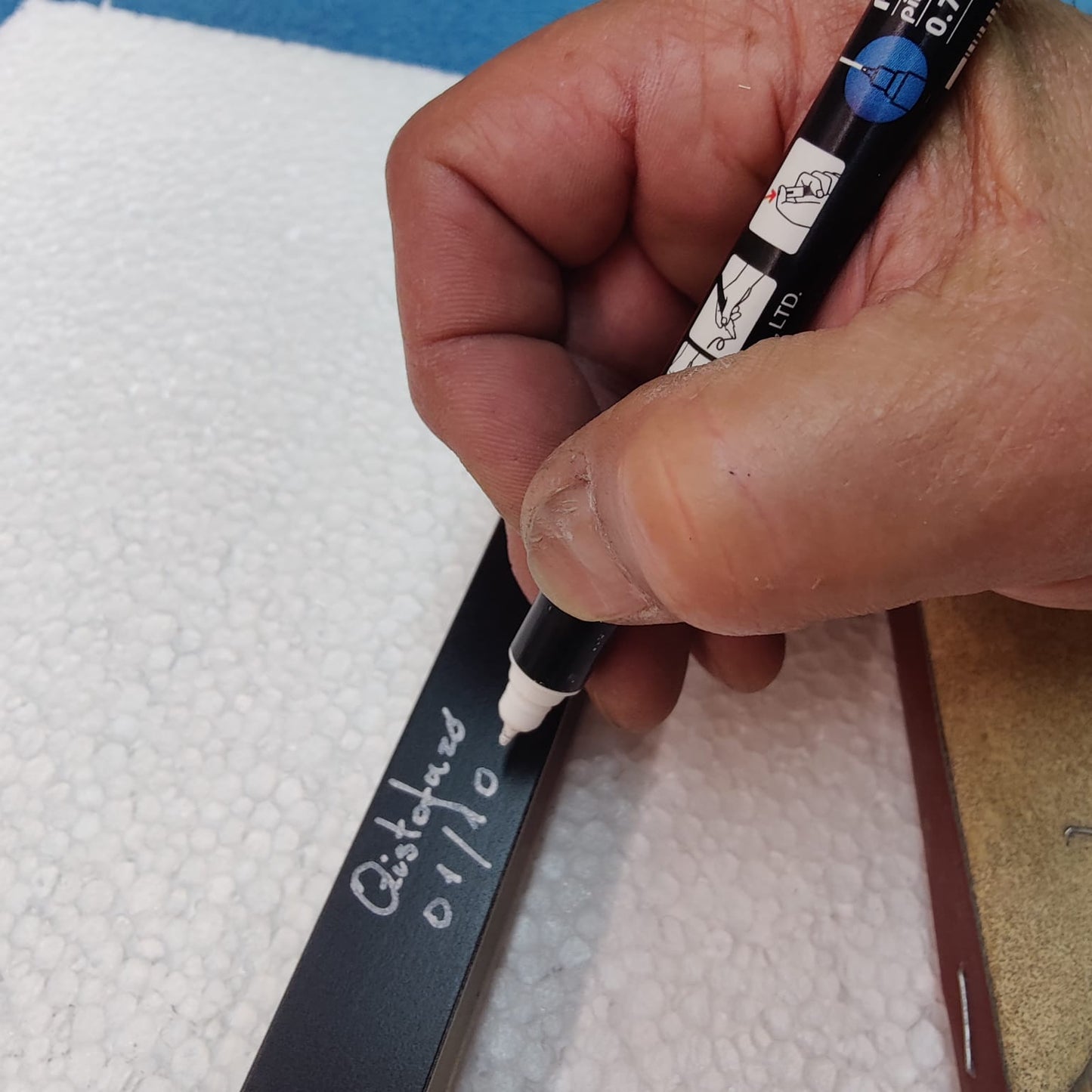 Hand signing a handcrafted lamp in the CristofaroLuce atelier, final gesture of an artisanal lighting piece before completion