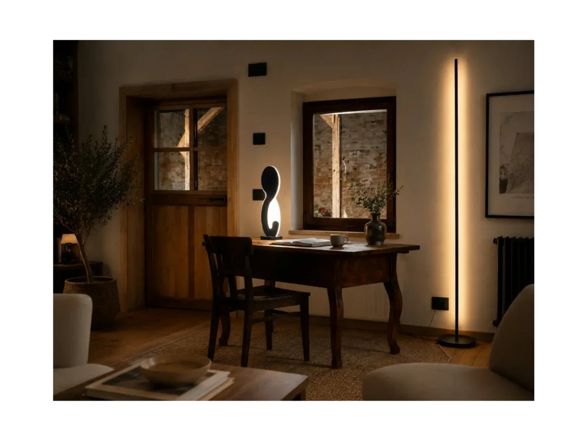 Gica Contra Floor Lamp 195 standing near a wall, showing its slim sculptural form and warm indirect light in a contemporary interior