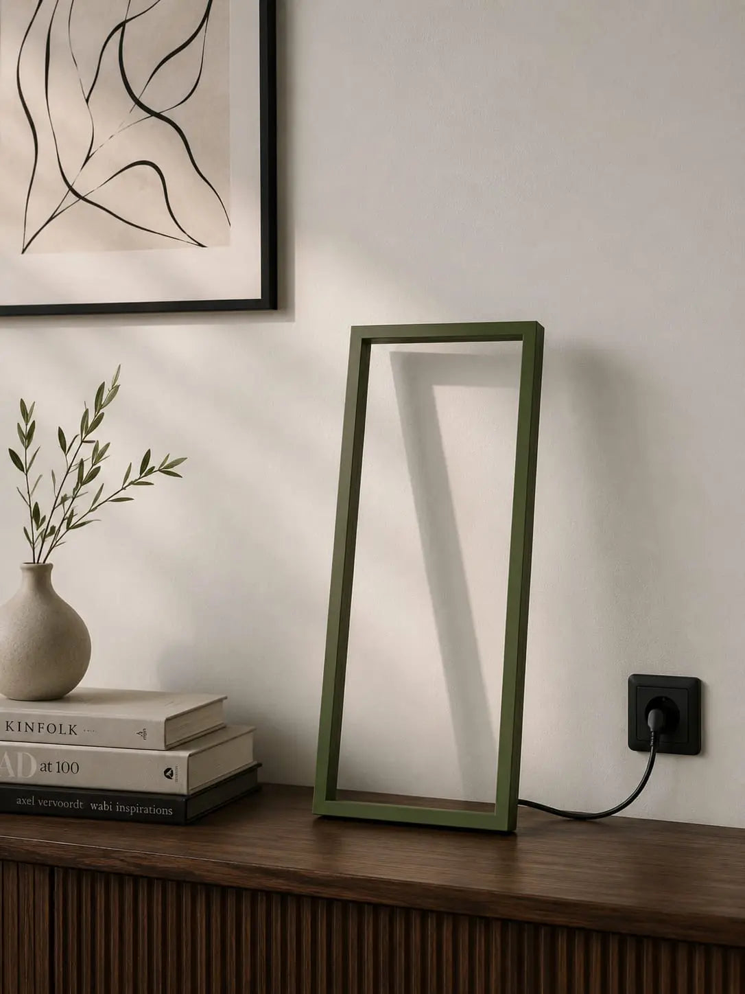 Cornice Table Lamp by Tommaso Cristofaro on a wooden sideboard, casting warm indirect light in an elegant mid-century modern living room.